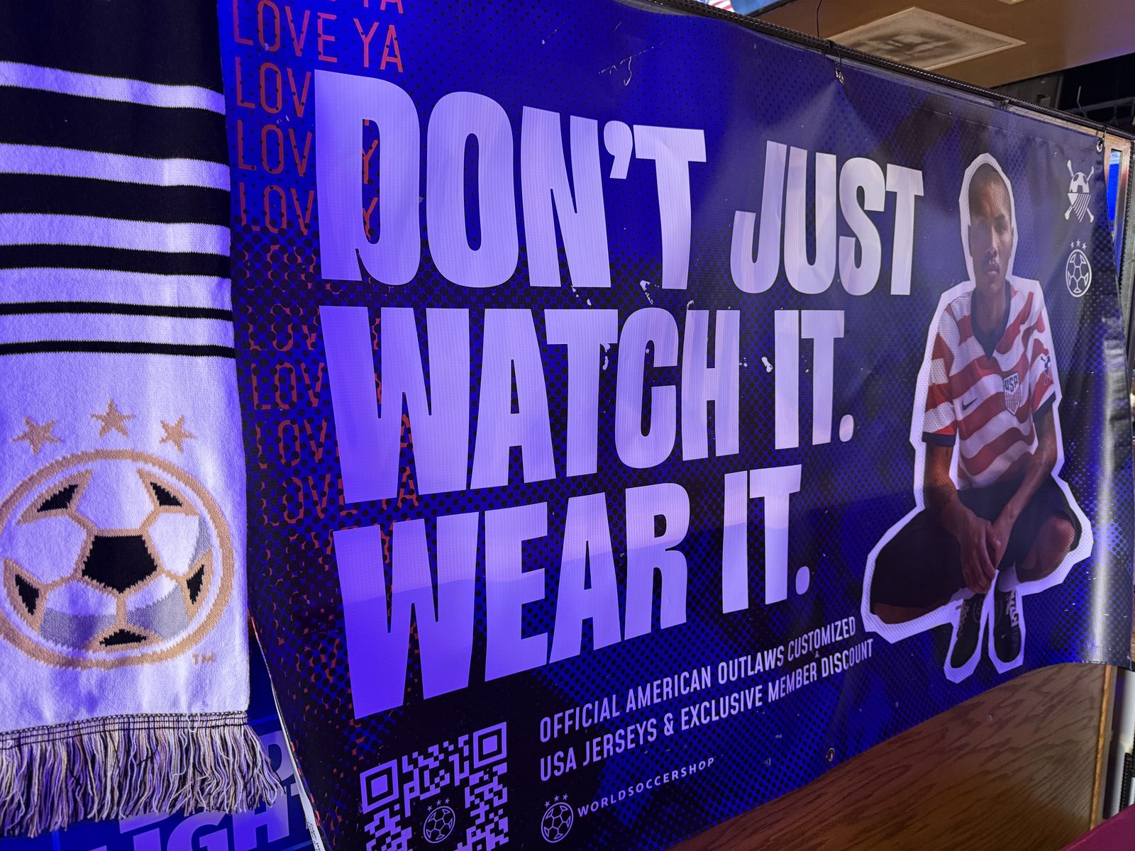 The WorldSoccerShop banner hanging in a chapter bar, reading Don't just watch it. Wear it.